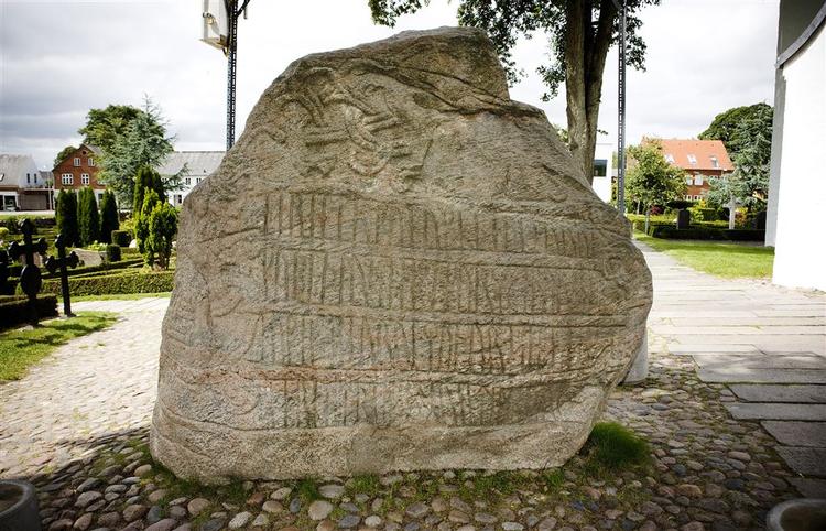 Skandinaviens største og prægtigste runesten, også kaldet 'Danmarks Dåbsattest', er udstyret med kristne symboler som blandt andre en kristusfigur og runeskrift. Den blev rejst i år 965 over Gorm den Gamle og Thyra Danebod af sønnen Harald Blåtand. 