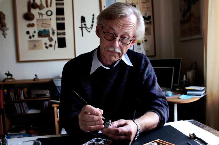 Detaljekunst.  Øverst en dansk soldat med reglementeret, men formmæssigt besværlig hjelm. Nederst er Christian Raun i gang med at give en figur kolorit med akrylfarve. Det stiller på grund af formatet og idealet om autenticitet ganske store krav til koncentration og finmotorik. Foto: Per Folkver 
