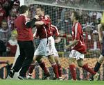 Dommer Herbert Fandel (yderst til højre på vej ud af billedet) er i høj fart på vej væk fra 'fodboldtossen', som Michael Gravgaard har fået godt fat i under kampen for lidt over to år siden. Arkivfoto. 