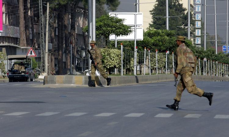 Pakistanske kommandosoldater indtager løbende position i en aktion for at befri militærpersonale, der i går blev taget som gidsler af talebanere. 