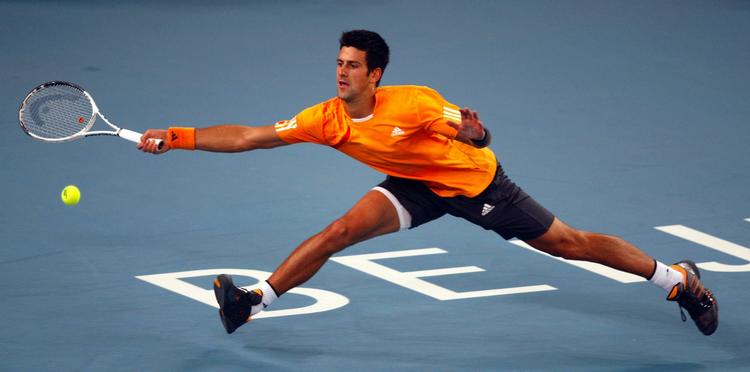 Novak Djokovic strækker sig langt for at nå en bold fra Marin Cilic i finalen ved China Open. 