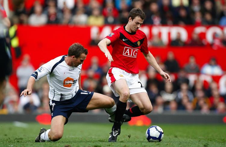Manchester Uniteds Jonny Evans (th.) går forbi Boltons Kevin Davies. 