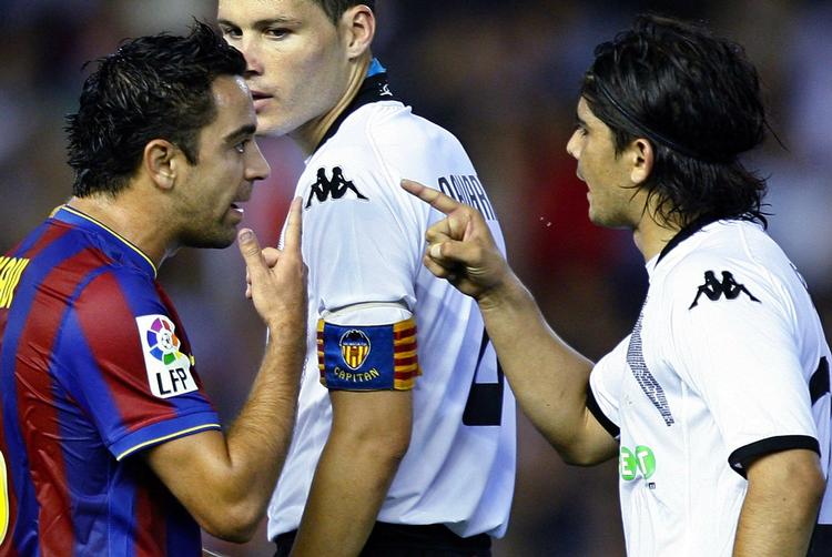 Xavi (til venstre) lufter sine frustrationer over for Valencias  Ever Banega. 