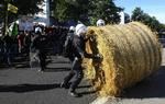 Politiet fjerner en halmballe, som vrede landmænd havde brugt til at blokere en vej under en demonstration ved  landbrugsministrenes møde i  Luxembourg i dag. 