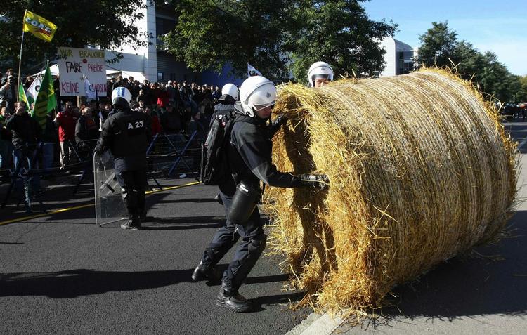 Politiet fjerner en halmballe, som vrede landmænd havde brugt til at blokere en vej under en demonstration ved  landbrugsministrenes møde i  Luxembourg i dag. 