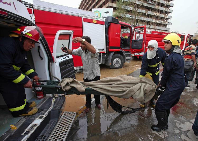 Blodbad. En af de mange omkomne efter bombeangrebet i Bagdad bliver løftet ind i en ambulance. 
