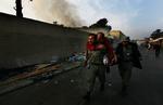 Terroroffer: Tysker bæres væk fra angrebet i Kabul af afghansk politibetjent. 