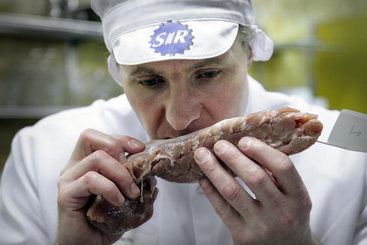 Slagter Christian Friis tjekker lugten af et råt stykke svinemørbrad. Arkivfoto. 