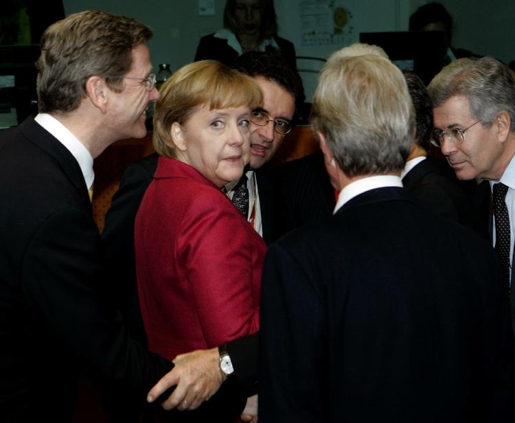 Korridorsnak. Tysklands kansler Angela Merkel drøfter sagen i en pause i forhandlingerne med repræsentanter for Tysklands og Frankrigs delegation. 