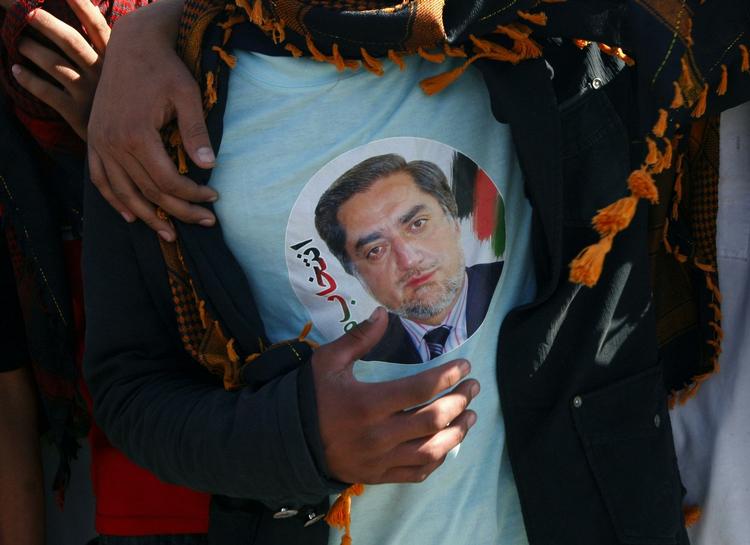 Kampgejst. Tilhængere af Abdullah Abdullah viser deres støtte ved at være tøj med hans ansigt. 