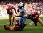 Titans-spilleren Chris Johnson bliver nedlagt af de Patrick Willis og Mark Roman fra San Francisco. 