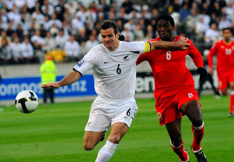VM-opgør. New Zealand's Ryan Nelsen i nærkamp med Bahrains Jaycee John Okwunwanne. 