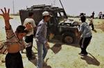 Irak. Foto fra 2005 i Basra viser irakiske drenge, der leger ved et udbrændt britisk militært køretøj. 