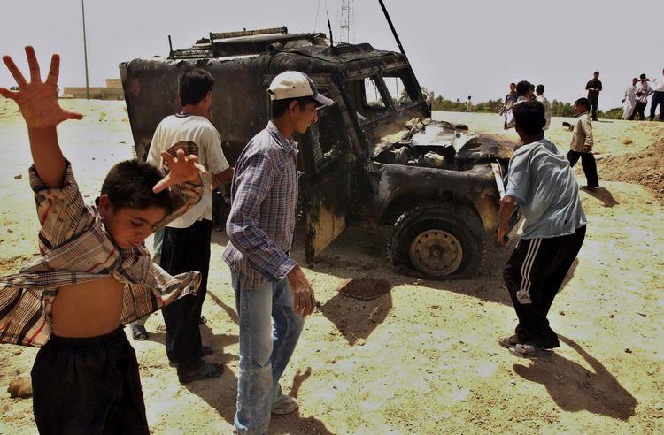 Irak. Foto fra 2005 i Basra viser irakiske drenge, der leger ved et udbrændt britisk militært køretøj. 