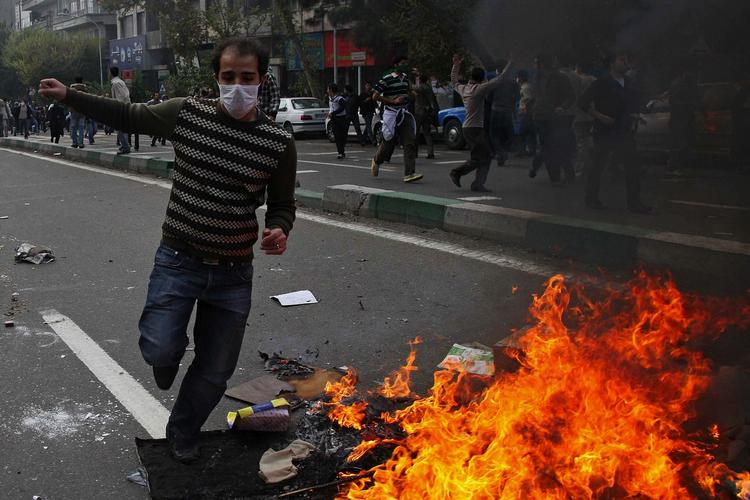 Oprør. En iransk aktivist flygter fra sikkerhedspolitiet, under de seneste demonstrationer i Teheran i Iran. Fotoet er smuglet ud af Iran og overgivet til nyhedsbureauet AP. 