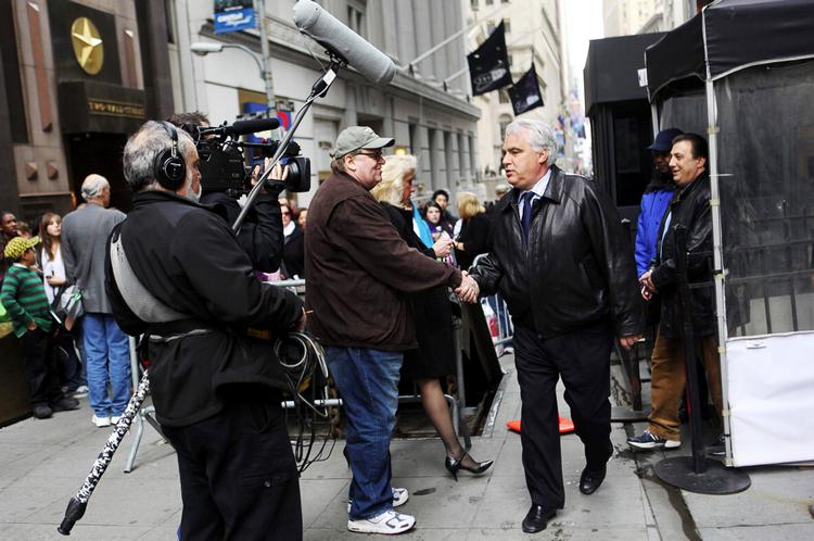 Arbejdsmetode.  Michael Moore under optagelserne af sin seneste film, hvor han er i gang med at afkræve forklaringer fra folk, der arbejder på Wall Street i New York. Foto: AP 