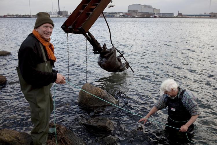 Lettet. Jens Galschiøt dirigerer redningsaktionen, mens bronzestøber Kurt Lilliendal Hansen er hoppet i vandet. 