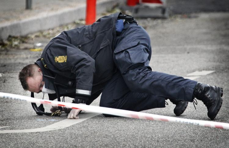 En betjent undersøger tekniske spor efter skyderiet på Frederiksberg. 