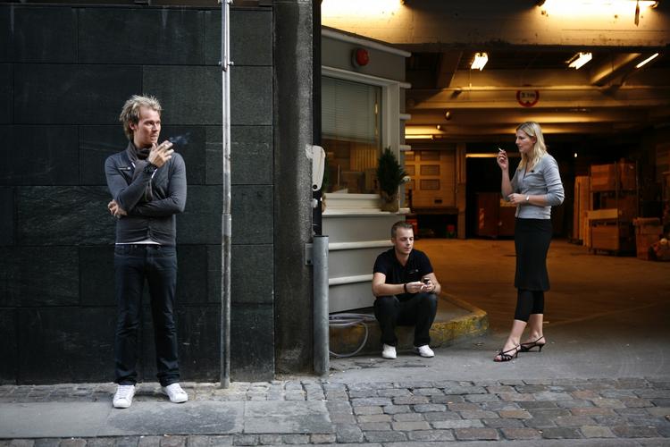 Rygepause. Mange rygere må sande, at det er nye tider for rygere på arbejdspladsen. Her er det personale, som ryger på gaden ved parkeringshuset foran stormagasinet Illum i København. (arkivfoto) 