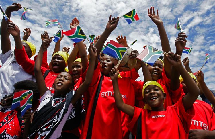 kultursammenstød. Børn modtager Fifas repræsentanter før et møde på Robben Island, Sydafrika, i går. Lodtrækningen i aften kommer nok mere til at ligne et glat Hollywood-show. 