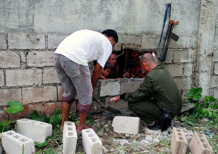 Fangeflugt. Fængselspersonale i det lokale fængsel på øen Basilan i det sydlige Filippinerne er ved at dække et af de huller til, som mindst 31 militante islamister flygtede ud igennem. 