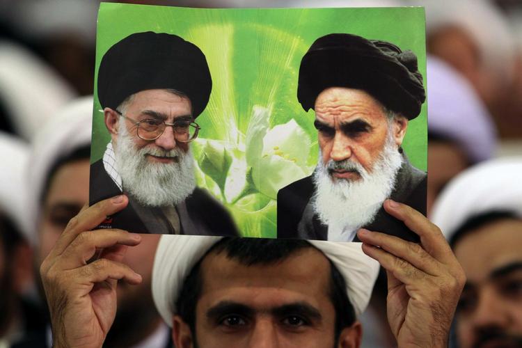 Støtter. Iranske præster mødtes i går med Irans øverste leder, ayatollah Ali  Khamenei. Her holder en præst hans foto (tv.) sammen med et billede af ayatollah Khomeini. 