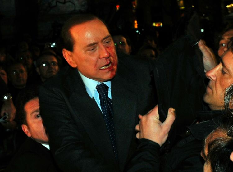 Overfaldet. Italiens premierminister Silvio Berlusconi umiddelbart efter at være ramt i hovedet af en figur. 