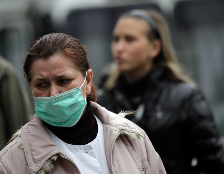 Pandemi. Dødsfaldene under en sæsoninfluenza og en pandemi opgøres meget forskelligt, siger WHO. Her søger en kvinde i Moldova at beskytte sig mod virus. (arkivfoto). 