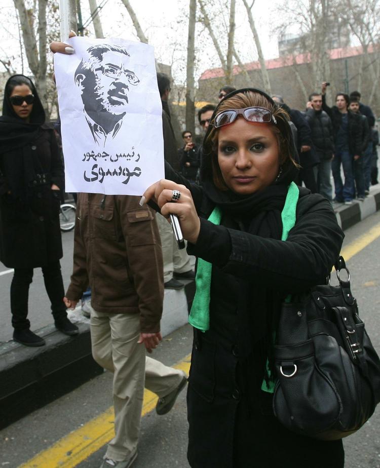 uroligheder. En iransk demonstrant med en løbeseddel med et portræt af oppositionslederen Mir Hossein Mousavi. Hans 20-årige nevø er angiveligt blandt de demonstranter, der blev dræbt i går. . 