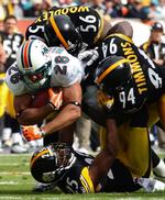 Ude. De forsvarende NFL-mestre, Pittsburgh Steelers, kommer ikke med i slutspillet. Her bliver safety Ryan Clark (25) stoppet af en Miami-spiller. 