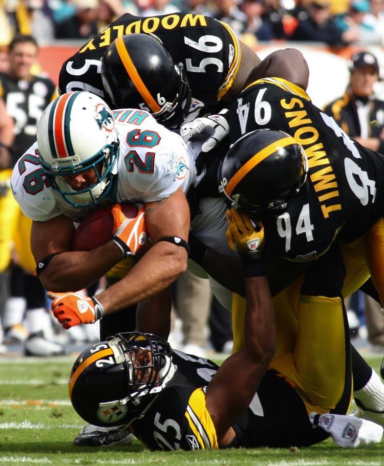 Ude. De forsvarende NFL-mestre, Pittsburgh Steelers, kommer ikke med i slutspillet. Her bliver safety Ryan Clark (25) stoppet af en Miami-spiller. 