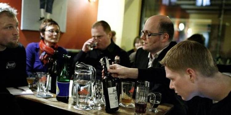 Øl-entusiaster smager på dråberne ved en tidligere lejlighed på Ølbaren på Nørrebro. 