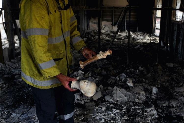 Brandskade. En brandmand gennemsøger ødelagt bohave i et af de huse, der er blevet raseret af ilden. 