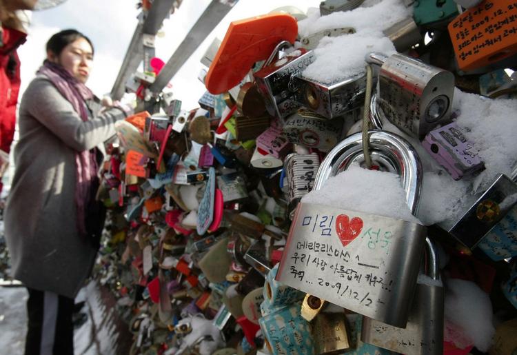 Unge par i Sydkorea hænger kærlighedslåse foran Seoul Tower og smider nøglen væk i håb om evig kærlighed. 