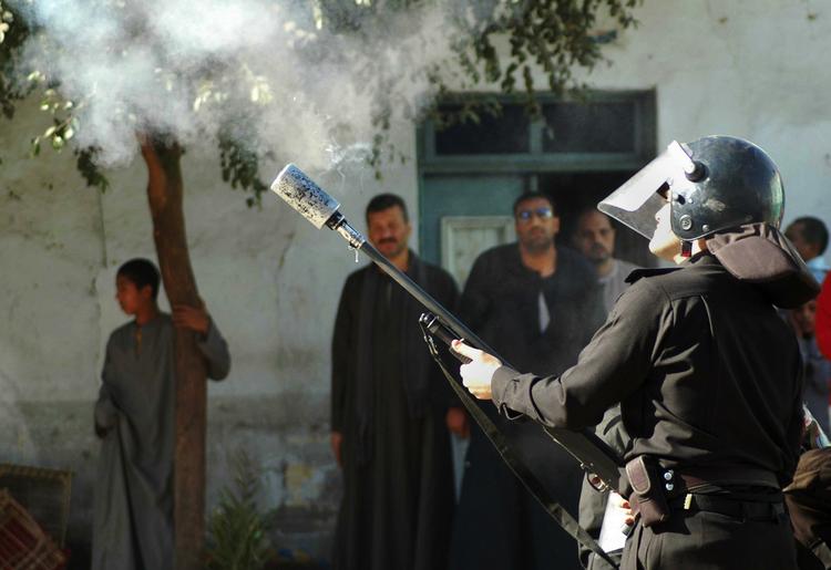 PROTEST. Egyptisk betjent affyrer tåregas mod kristne, der protesterer mod angreb foran kirke. Arkivfoto. 