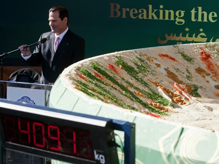 Verdensrekord. Restauratøren bag den nye hummus-rekord Jawdat Ibrahim, står ved siden af den store parabolmodtager, som blev brugt til at servere hummusen i. 