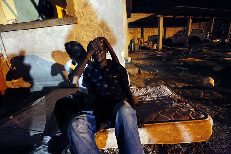 Fortvivlelse. En haitianer trøster sin svoger, hvis gravide hustru blev dræbt, da et fire-etagers hus stytrtede sammen under jordskælvet. 