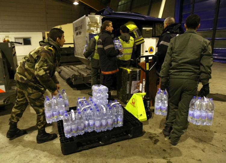 katastrofehjælp.  Franske brandmænd og soldater er ved at læsse rent vand og nødhjælpsudstyr på et fly til Haiti, hvor eksperter frygter udbrud af sygdomme efter jordskælvet. 