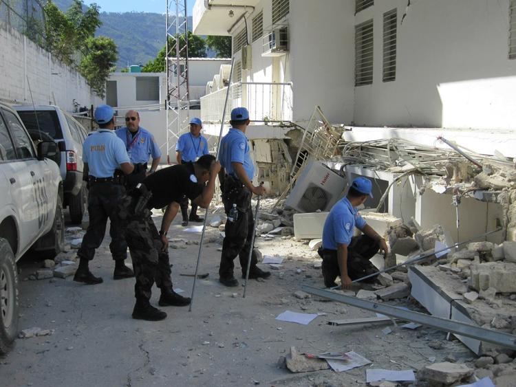 Eftersøgning. Filippinske politifolk leder efter eventuelle sårede kolleger i en af de sammenstyrtede FN-bygninger i Haitis hovedstad Port-au-Prince. 