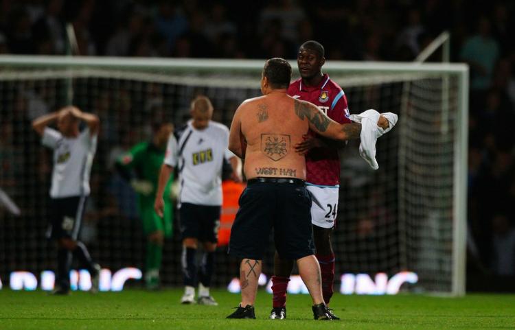 invasion. En West Ham-tilhænger holdes tilbage af en af spillerne under det dramatiske lokalopgør mellem West Ham og Millwall i august 2009. Arkivfoto. 