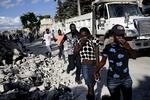 Indbyggere prøver at beskytte sig mod stanken af lig. Lastbilen i baggrunden er fyldt op med afdøde haitianere. 