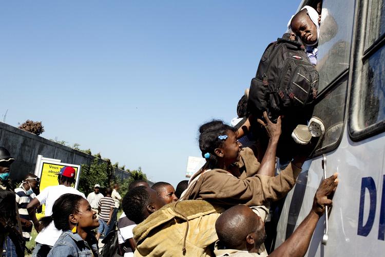 Beboere forsøger at komme ud af Port-au-Prince ved at fylde en bus mod Port Liberte til bristepunktet. 
