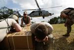 Nødhjælp. Amerikanske soldater går i dækning, mens en helikopter lander tæt på Port-au-Prince. 
