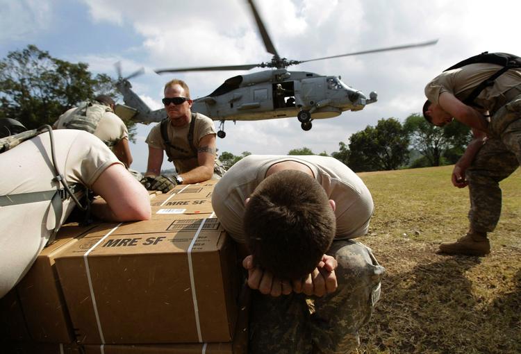 Nødhjælp. Amerikanske soldater går i dækning, mens en helikopter lander tæt på Port-au-Prince. 