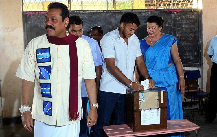 Valghandling. Præsident Rajapaksa på et valgsted, mens sønnen afgiver sin stemme, og hustruen ser til. 