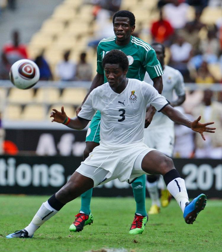 folkehelt. Ghanas Asamoah Gyan (front) blev matchvinder i semifinalen mod Nigeria. 