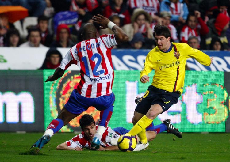 snurrig. Lionel Messi (th) spillede igen en stor kamp for Barcelona, der vandt knebent mod Sporting Gijon. 
