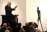 Rekordkunst. Auktionarius Henry Wyndam i færd med at sælge Alberto Giacomettis skulptur 'L'Homme Qui Marche I' for rekordsummen 65 millioner pund. Arkivfoto. 