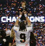 Præmiedreng. Dew Brees holder sin egen pokal i luften, sønnen Baylen, efter sejren i Super Bowl-finalen. 