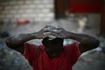 En formodet røver holder hænderne oven på hovedet. Politiet i Haiti og internatinale redningsstyrker forsøger at begrænser kriminaliteten, der blomstrer i det kaos, der har efterfulgt jordskælvet. 